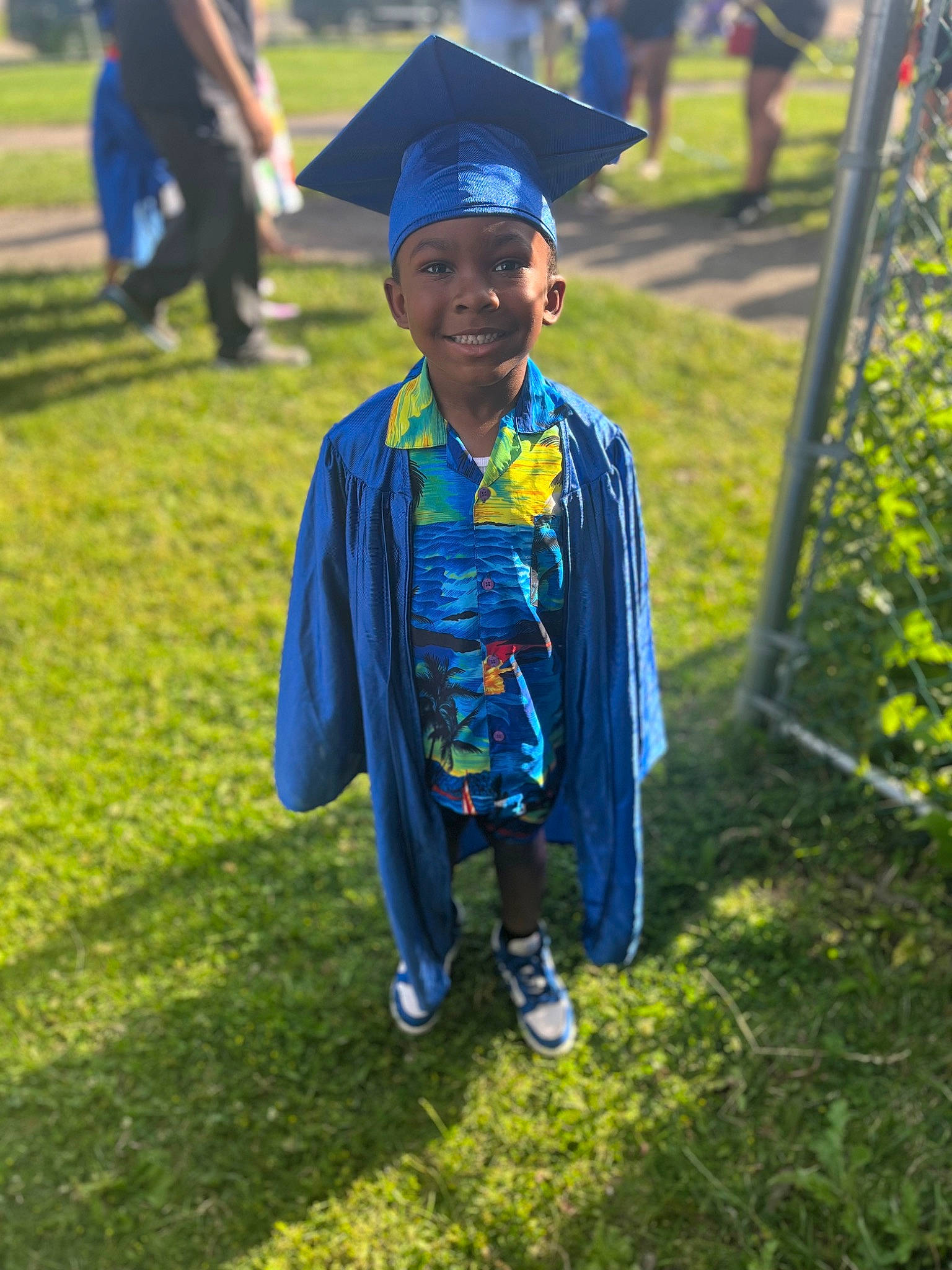 Jabari is registered to the contest to win money with this photo: academic_dress, academic_institution, clothing, electric_blue, event, fun, gesture, graduation, grass, grassland, happy, hat, headwear, joy, leisure, mortarboard, outerwear, person, phd, scholar