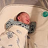 newborn, baby, infant, sleeping, smiling, face, portrait, blanket, swaddle, crib, bassinet, pacifier, mitten, clothing, indoor, nursery, cozy, lying_down, bed, photography