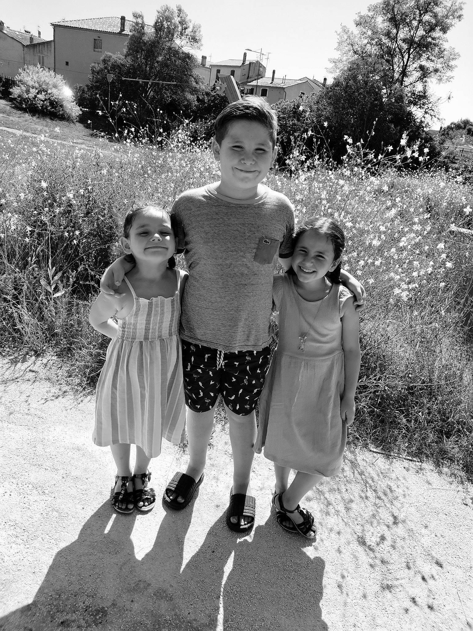 Wyatt a rejoint le concours — aidez-le/la à gagner de superbes lots ! black, black_and_white, child, dress, footwear, fun, gesture, grass, happy, head, interaction, joy, monochrome, people_in_nature, person, plant, sky, standing, style, toddler