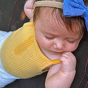 Wrenleigh is registered to the contest to win money with this photo: baby, child, sleeping, yellow_clothing, blue_bow, headband, infant, face, hand, closeup, peaceful, soft_lighting, cute, young_child, skin, eyelashes, fingers, resting, portrait, indoors