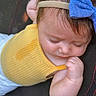 baby, blue_bow, child, closeup, cute, eyelashes, face, fingers, hand, headband, indoors, infant, peaceful, portrait, resting, skin, sleeping, soft_lighting, yellow_clothing, young_child