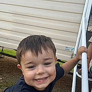 Sonny joined the competition — help win amazing prizes! child, boy, smiling, outdoor, railing, metal, grassy, dirt, short_hair, black_shirt, happy, face, hand, playful, daylight, casual_clothing, young, person, background, nature