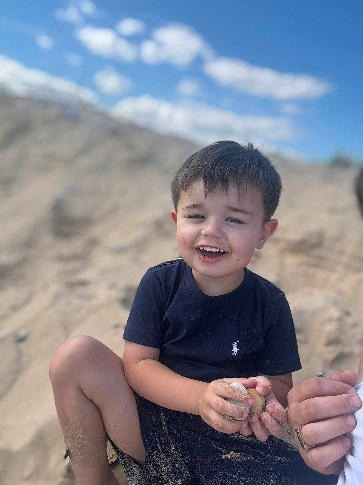 Sonny joined the competition — help win amazing prizes! child, boy, sand, beach, smile, happy, outdoor, sky, clouds, short_hair, tshirt, playing, summer, nature, fun, casual_clothing, person, daytime, sand_on_skin, relaxed