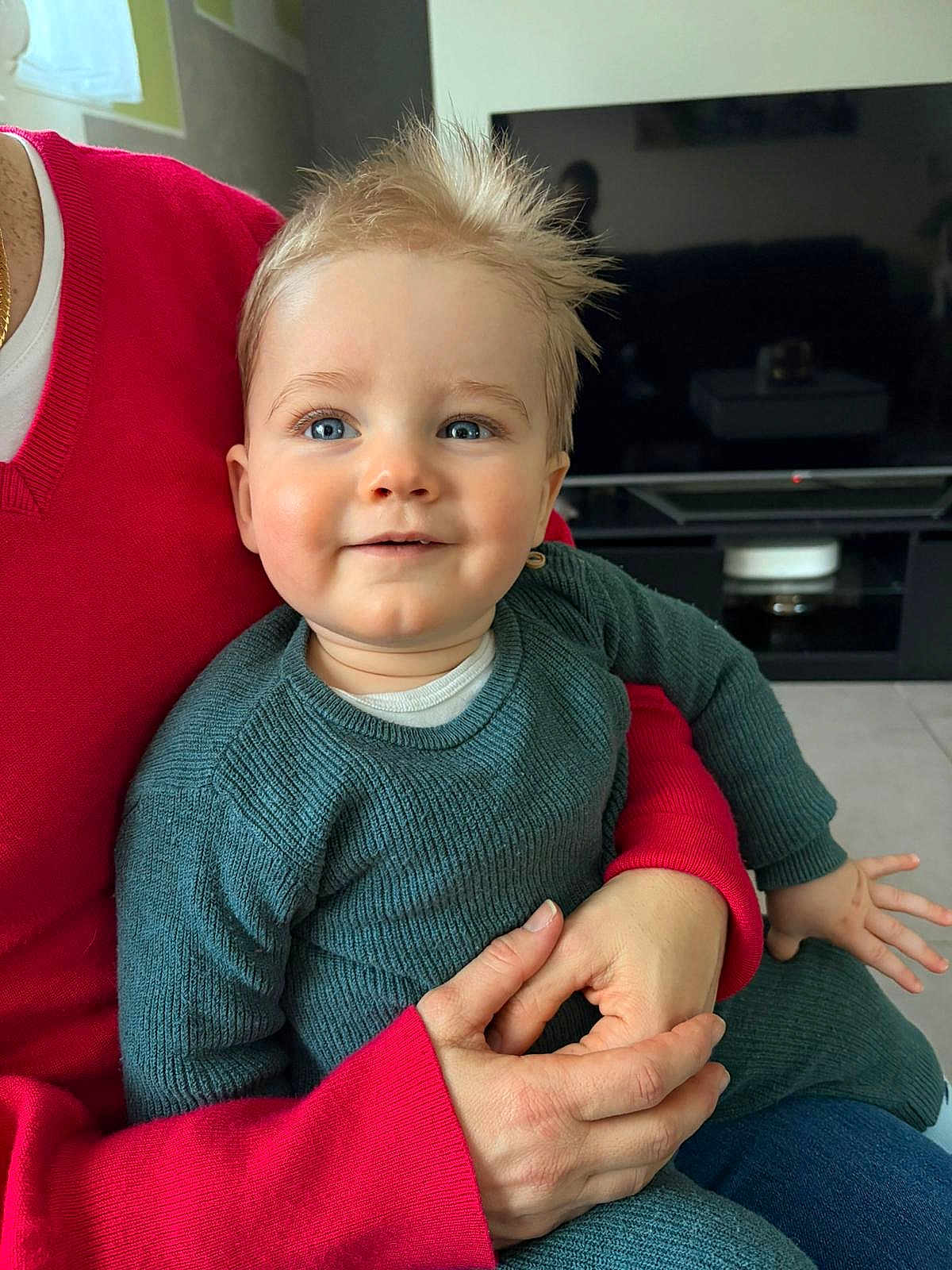 Tom a rejoint le concours — aidez-le/la à gagner de superbes lots ! baby, toddler, child, blue_eyes, spiky_hair, knit_sweater, green_sweater, red_sweater_sleeve, adult_hand, holding, smile, cheeks, living_room, television, tv_screen, portrait, indoor, cuddling, closeup, skin