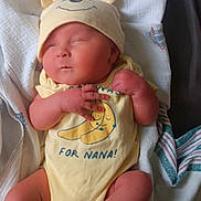 Hunter is registered to the contest to win money with this photo: newborn, baby, sleeping, yellow_onesie, hat, bear_ears, blanket, infant, cute, soft, cozy, toddler, resting, clothing, wrapped, peaceful, indoors, child, person, small