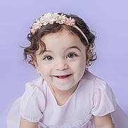 Louise a rejoint le concours — aidez-le/la à gagner de superbes lots ! baby, child, closeup, curly_hair, cute, dress, earrings, eyewear, face, flower, happy, headband, innocence, pale_skin, portrait, purple_background, smiling, studio, toddler, young
