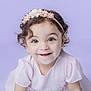 baby, child, closeup, curly_hair, cute, dress, earrings, eyewear, face, flower, happy, headband, innocence, pale_skin, portrait, purple_background, smiling, studio, toddler, young