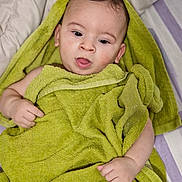 Nassim participe au concours pour gagner de l'argent avec cette photo : baby, blanket, child, comfortable, cozy, cute, expression, face, green, hand, indoors, infant, lying_down, person, portrait, skin, sleeping_area, soft, towel, young