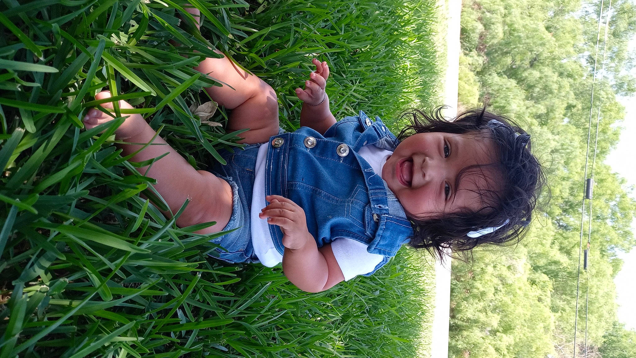 Dariana is registered to the contest to win money with this photo: baby_toddler_clothing, barefoot, child, facial_expression, foot, fun, gesture, grass, grassland, happy, lawn, leisure, meadow, people_in_nature, person, plant, skin, smile, thumb, toddler