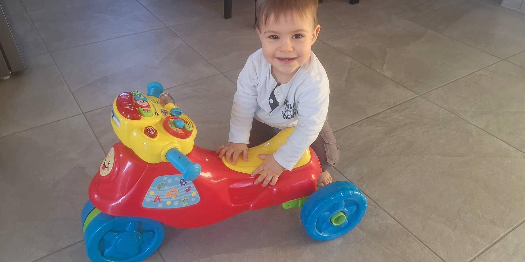 Timothé a rejoint le concours — aidez-le/la à gagner de superbes lots ! baby, baby_playing_with_toys, baby_toddler_clothing, child, event, flooring, fun, joy, leisure, person, plastic, play, recreation, riding_toy, sitting, smile, tire, toddler, toy, toy_vehicle