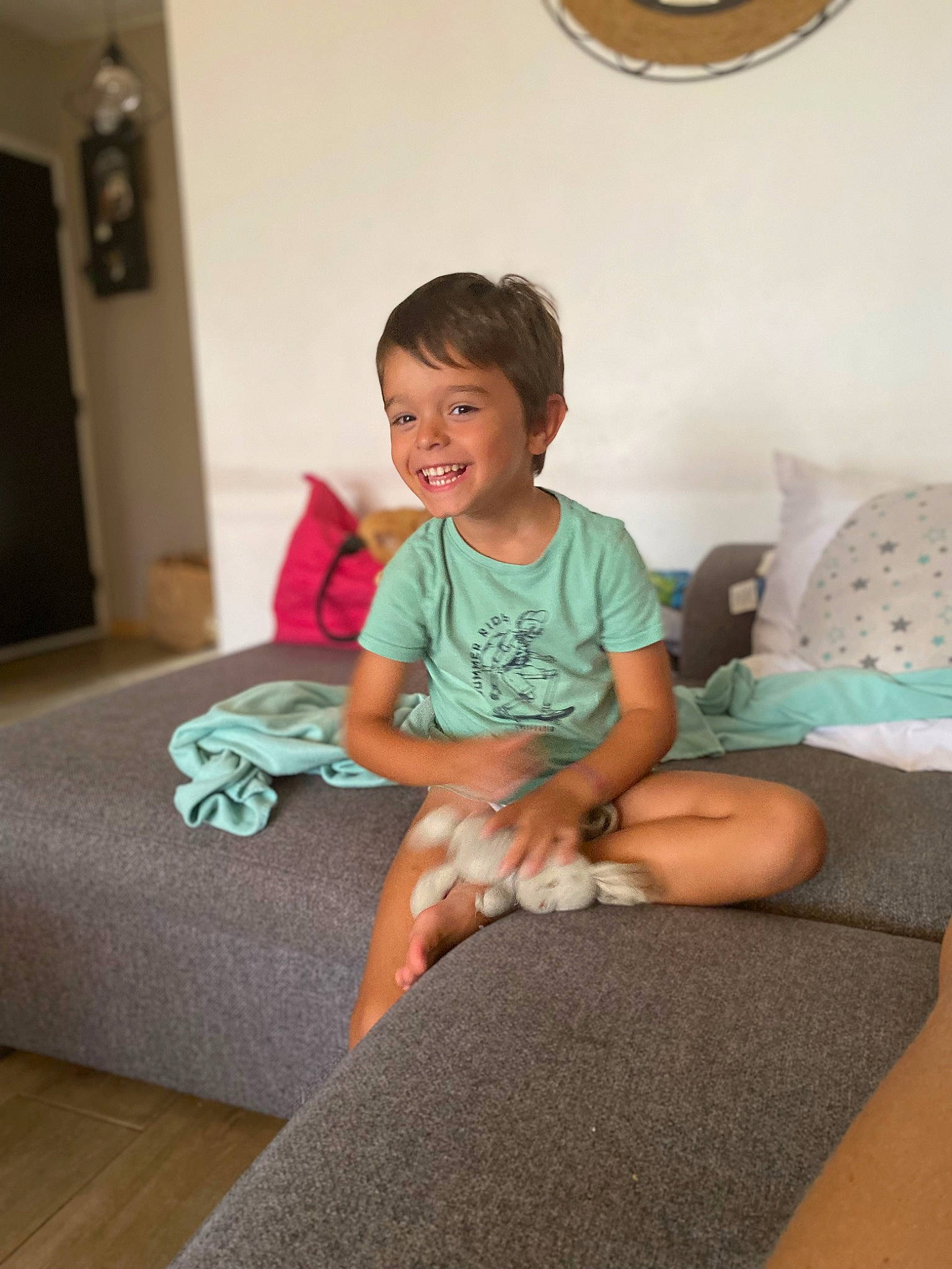 Léo a rejoint le concours — aidez-le/la à gagner de superbes lots ! baby_toddler_clothing, child, comfort, floor, flooring, happy, human_leg, joy, knee, leisure, linens, living_room, person, picture_frame, pillow, room, skin, smile, t_shirt, thigh