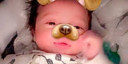 Malachi is registered to the contest to win money with this photo: baby, infant, newborn, face, dog_filter, dog_ears, dog_nose, blanket, onesie, sheep_pattern, hand, hair, eyes, pajamas, zipper, cozy, bed, portrait, soft_lighting, cute
