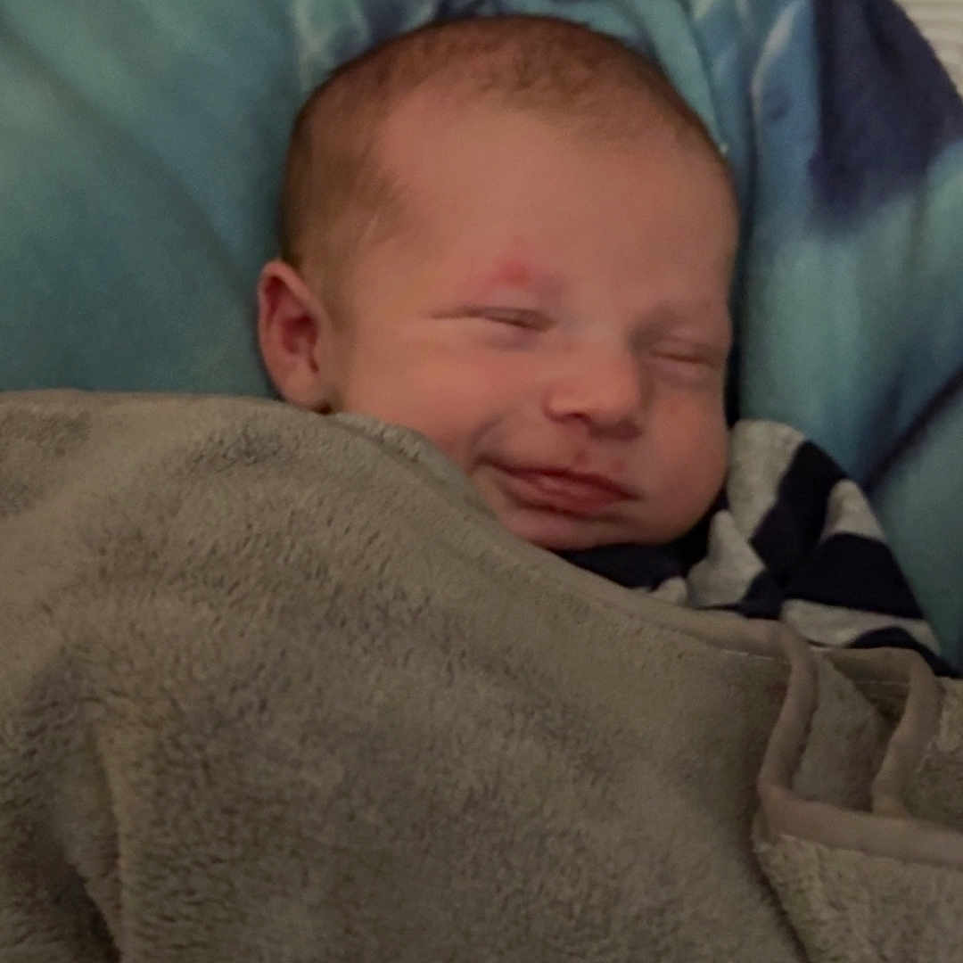 Apaullo joined the competition — help win amazing prizes! baby, blanket, blue, child, comfort, cozy, cute, face, gray, head, indoors, infant, peaceful, person, portrait, sleeping, smile, soft, warm, wrapped