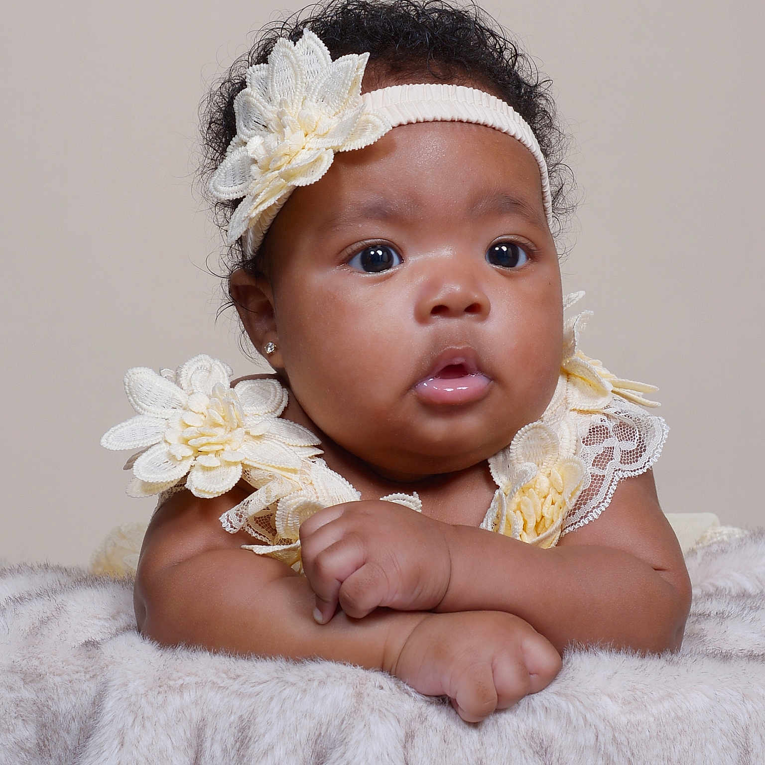Bahja is registered to the contest to win money with this photo: adorable, baby, blanket, child, clothing, curly_hair, cute, expression, eyes, face, flower, hands, headband, infant, innocent, portrait, resting, skin, soft, studio