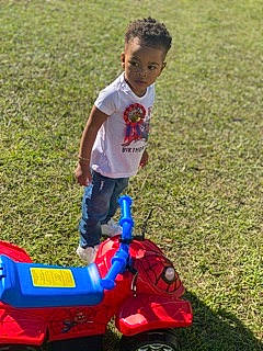 Kori is registered to the contest to win money with this photo: child, fun, grass, person, play, toddler, vehicle