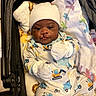 Ty'Aire Avant is registered to the contest to win money with this photo: baby, infant, stroller, blanket, mittens, hat, smile, face, clothing, cute, child, lying_down, indoor, soft, warm, toddler, person, colorful, patterned_clothing, comfort