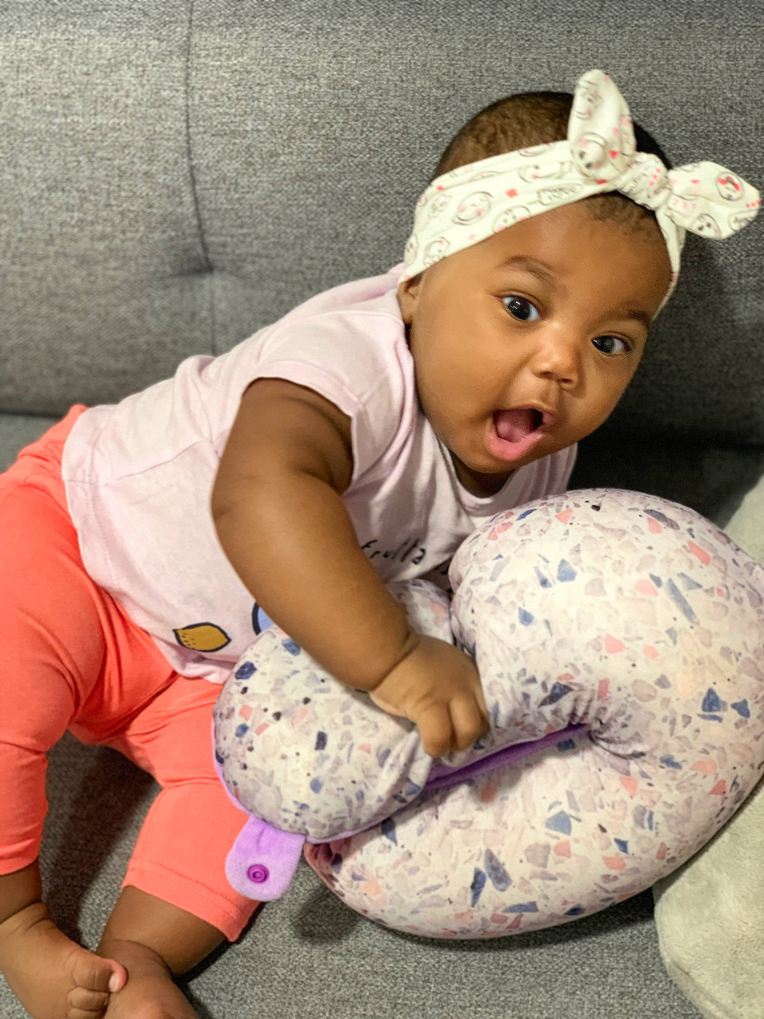 Joyce participe au concours pour gagner de l'argent avec cette photo : arm, baby, baby_toddler_clothing, cheek, child, child_model, ear, headgear, headwear, person, pink, sitting, skin, smile, surprise, toddler