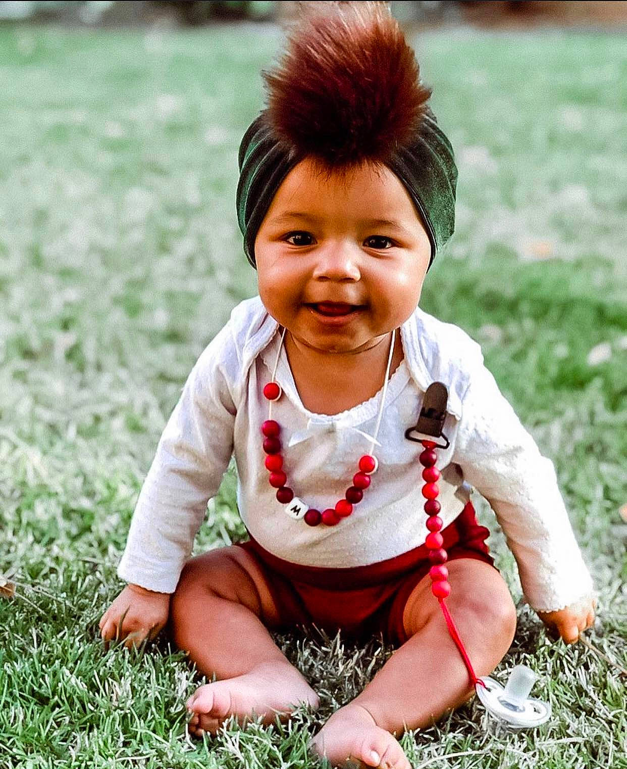 Myla is registered to the contest to win money with this photo: arm, blue, cheek, clothing, dress, eye, face, finger, fun, grass, green, head, human, lip, nature, people, person, product, recreation, sitting