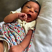 Charlotte Elizabeth is registered to the contest to win money with this photo: baby, infant, blanket, floral_pattern, pillow, resting, yawning, cute, skin, arm, hand, clothing, sleepy, newborn, portrait, soft, cozy, indoors, child, toddler
