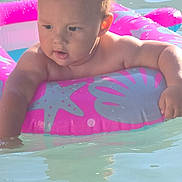 Xander is registered to the contest to win money with this photo: baby, child, inflatable_ring, pool, water, pink, starfish, seashell, summer, swimming, toddler, sunlight, outdoor, cute, play, fun, skin, arm, face, expression