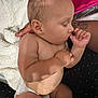 baby, sleeping, thumb_sucking, diaper, arm, tattoo, blanket, pillow, floral_pattern, skin, person, indoor, comfort, rest, infant, closeup, peaceful, cute, toddler, nap