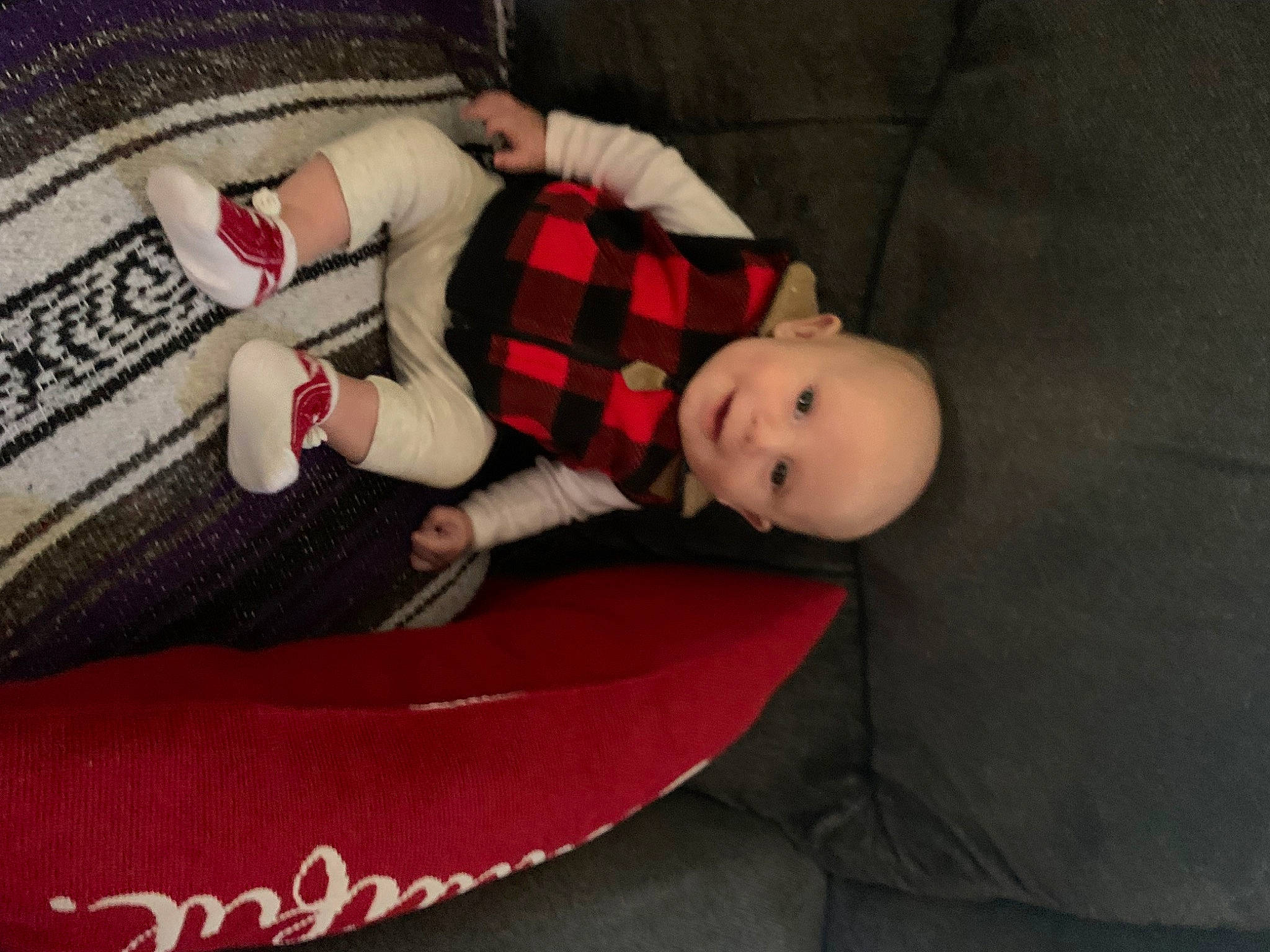 Dakoda is registered to the contest to win money with this photo: baby, baby_products, baby_toddler_clothing, carmine, child, comfort, flooring, fur, head, linens, pattern, person, plaid, room, sitting, sleeve, sock, stuffed_toy, tartan, toddler