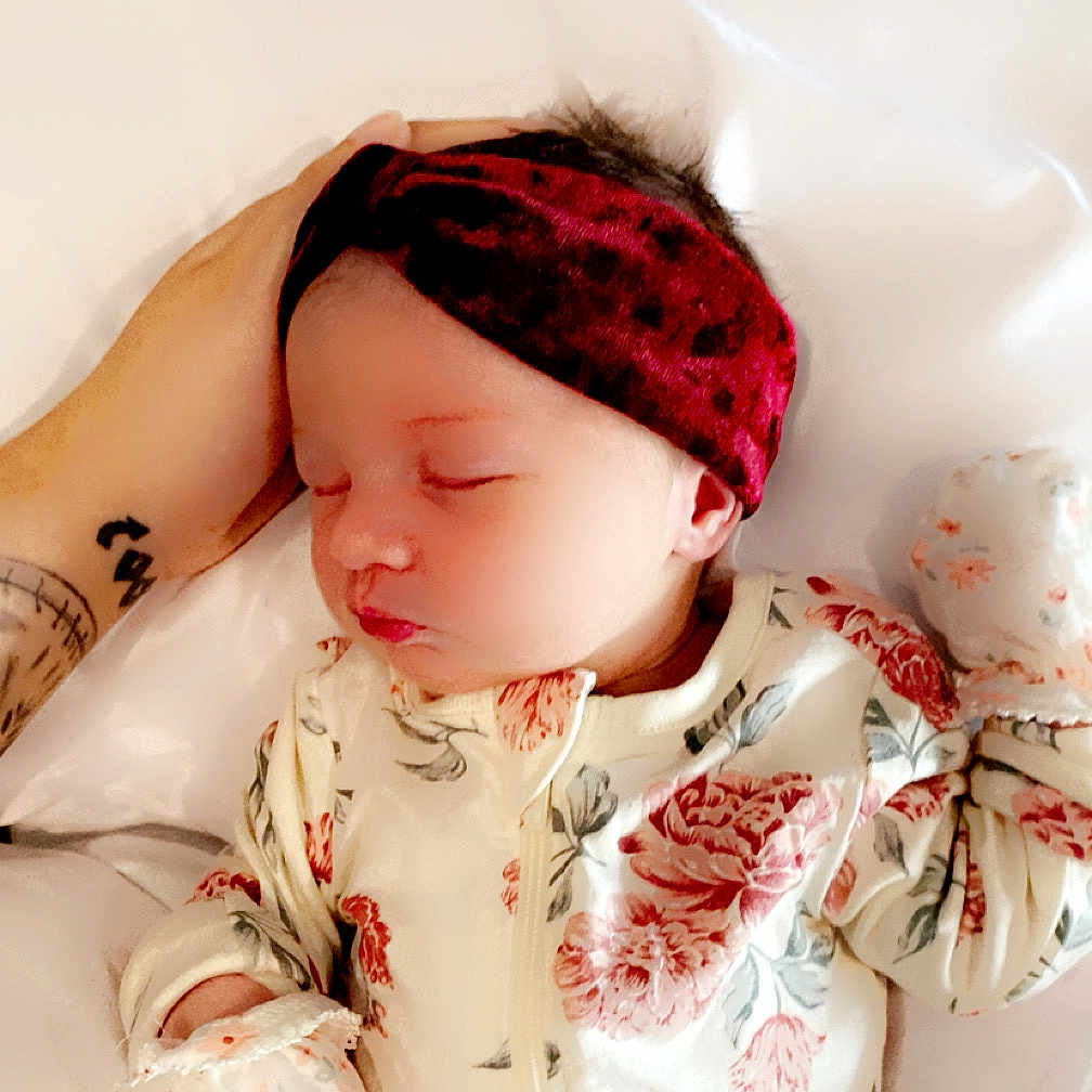 Avia is registered to the contest to win money with this photo: baby, child, closeup, comfort, cute, fabric, floral_clothing, hand, headband, indoor, infant, newborn, onesie, peaceful, portrait, resting, sleeping, soft, tattoo, white_background