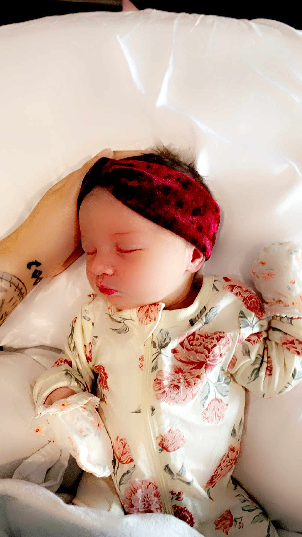 Avia is registered to the contest to win money with this photo: baby, sleeping, headband, floral_clothing, onesie, hand, tattoo, white_background, soft, peaceful, newborn, infant, portrait, resting, cute, child, indoor, closeup, fabric, comfort