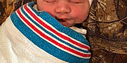 Avia is registered to the contest to win money with this photo: baby, blanket, camouflage, child, closeup, cozy, cute, fabric, face, hat, indoors, infant, newborn, pattern, peaceful, portrait, resting, sleeping, soft, wrapped