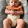 baby, infant, child, onesie, bib, cushion, seat, hands, legs, face, expression, indoor, cute, plush, comfort, skin, clothing, sitting, young, portrait