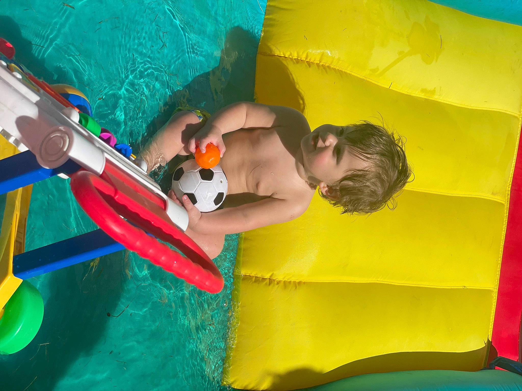 Gaige is registered to the contest to win money with this photo: ball, child, comfort, fun, games, grass, happy, inflatable, leisure, outdoor_play_equipment, people_in_nature, person, play, recreation, swimming_pool, toddler, toy, vacation, water