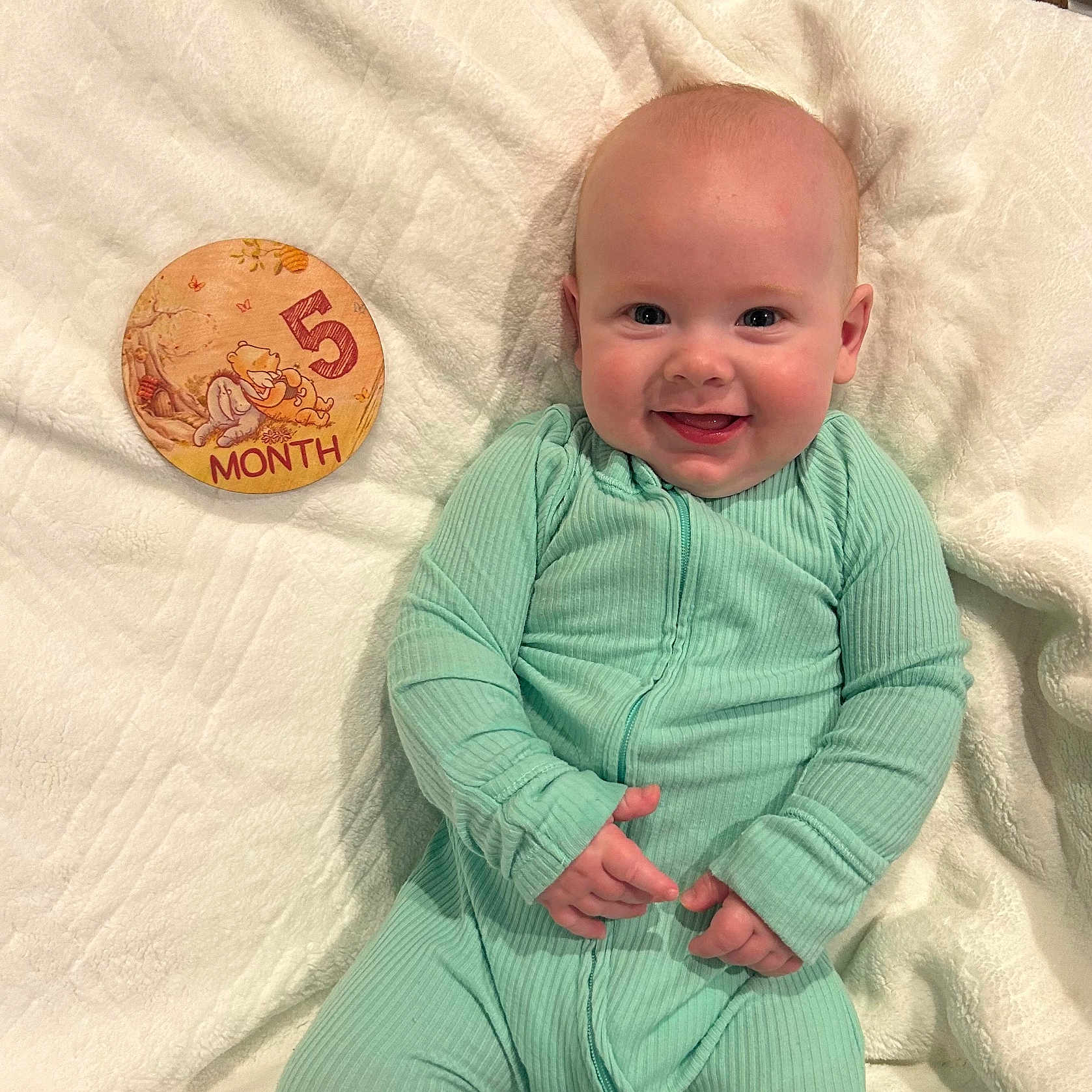 Dallen joined the competition — help win amazing prizes! baby, baby_clothing, blanket, child, cute, hands, happy, head, indoor, infant, lying_down, milestone, mint_green, onesie, portrait, skin, smiling, soft_texture, winnie_the_pooh, wooden_sign