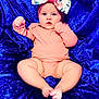 baby, infant, headband, bow, pink_clothing, blue_fabric, velvet, lying_down, chubby_legs, bare_feet, cute, portrait, child, soft_texture, curious_expression, indoors, closeup, person, skin, small_toes