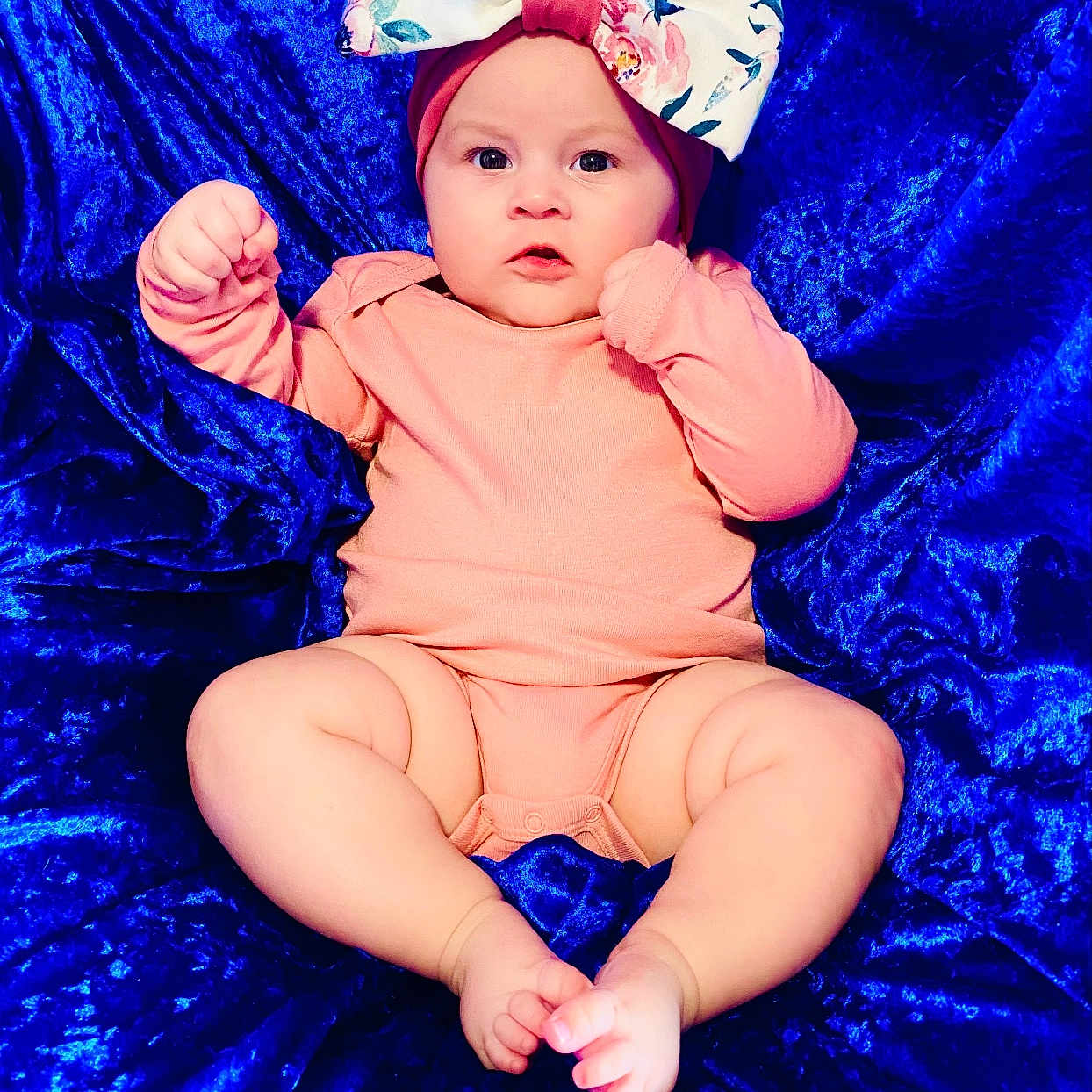 Larkyn joined the competition — help win amazing prizes! baby, bare_feet, blue_fabric, bow, child, chubby_legs, closeup, curious_expression, cute, headband, indoors, infant, lying_down, person, pink_clothing, portrait, skin, small_toes, soft_texture, velvet