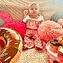 Larkyn joined the competition — help win amazing prizes! baby, child, infant, pink, donut, pillow, sprinkles, headband, clothing, food, dessert, plate, sitting, cute, indoor, soft_toys, patterned, colorful, happy, portrait