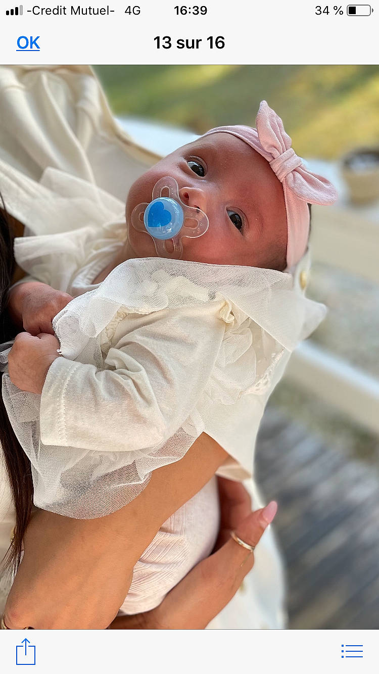 Véïna a rejoint le concours — aidez-le/la à gagner de superbes lots ! abdomen, baby, baby_products, baby_toddler_clothing, chest, child, comfort, eye, finger, gesture, happy, head, headwear, human_leg, linens, person, sitting, skin, thigh, thumb