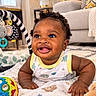 baby, child, infant, smiling, happy, portrait, curly_hair, indoor, living_room, blanket, toy, teddy_bear, playmat, couch, plant, home, sitting, tummy_time, colorful, family_photo
