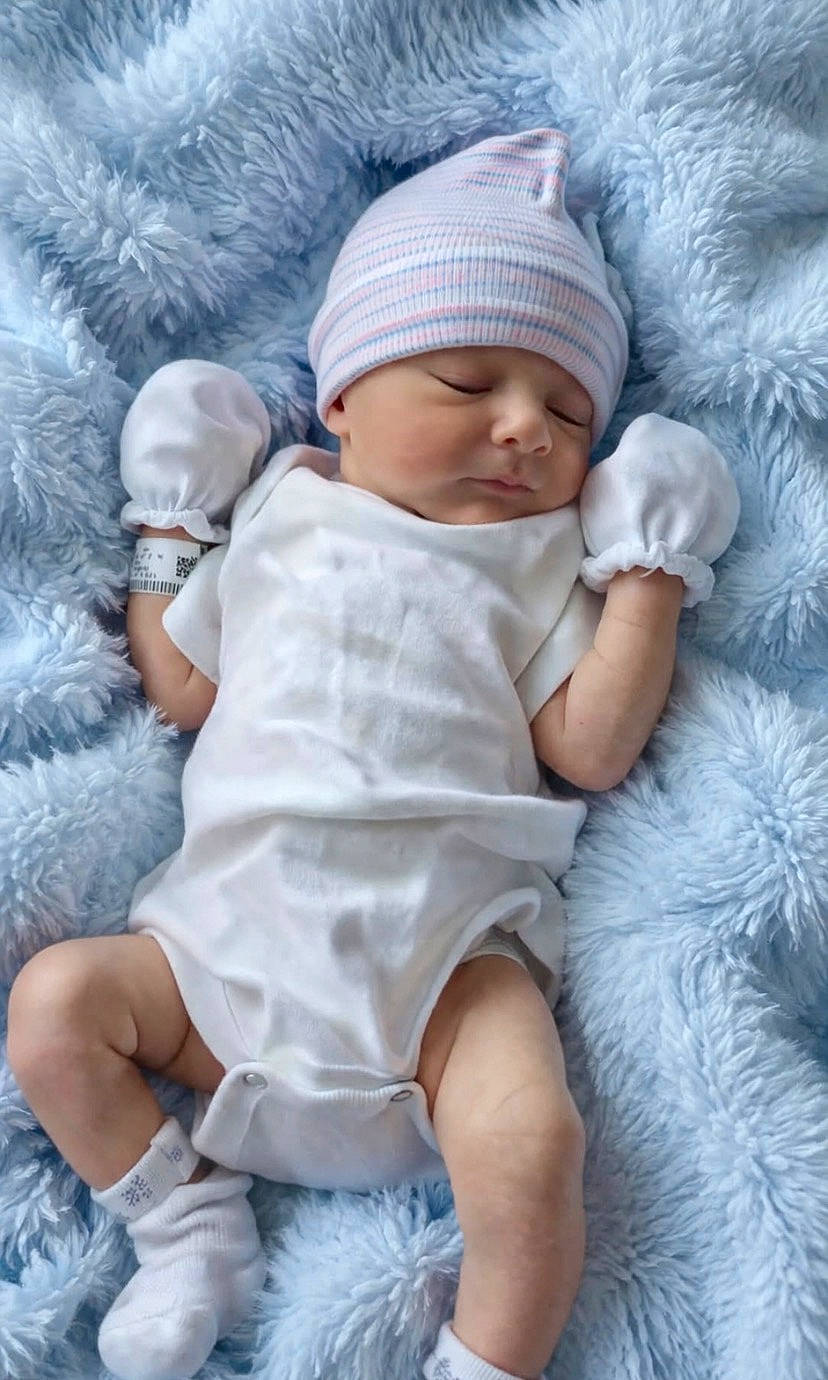 baby, blanket, blue_blanket, child, cozy, cute, hat, hospital_id_band, indoors, infant, mittens, newborn, peaceful, person, portrait, resting, sleeping, socks, soft, white_clothing