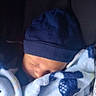 baby, sleeping, blanket, blue, hat, infant, cozy, soft, face, peaceful, child, clothing, portrait, closeup, comfort, rest, seat, dark_background, warm, cute