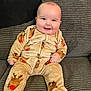 George joined the competition — help win amazing prizes! baby, child, clothing, couch, cozy, cute, face, gray_couch, hands, happy, home, indoors, infant, onesie, plush, portrait, reindeer_pattern, seated, smiling, young_child