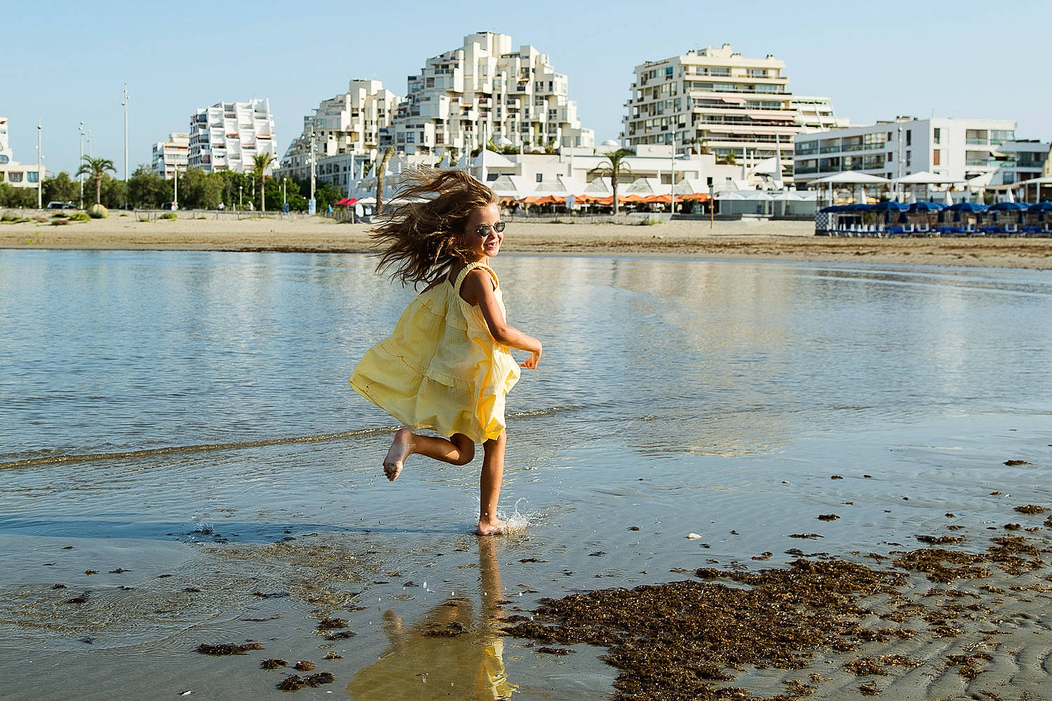 Cléa participe au concours pour gagner de l'argent avec cette photo : azure, bank, beach, coastal_and_oceanic_landforms, dress, fun, hair, happy, horizon, lake, leg, leisure, people_in_nature, people_on_beach, person, sky, sunlight, travel, tree, water