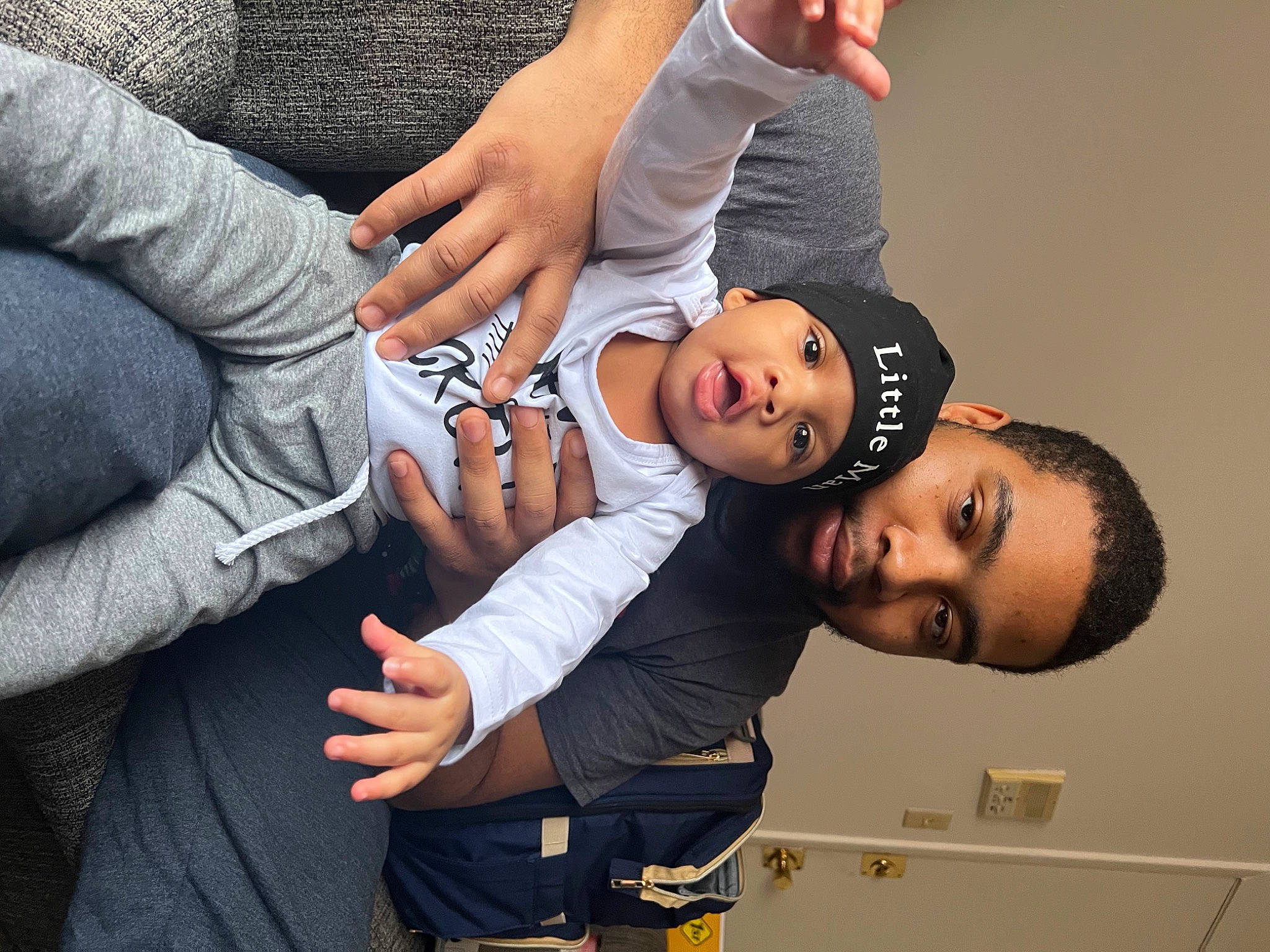 Kyrie is registered to the contest to win money with this photo: arm, baby, black_hair, child, elbow, event, eyelash, eyewear, finger, flash_photography, fun, gesture, hand, happy, headwear, nail, person, room, thumb, toddler