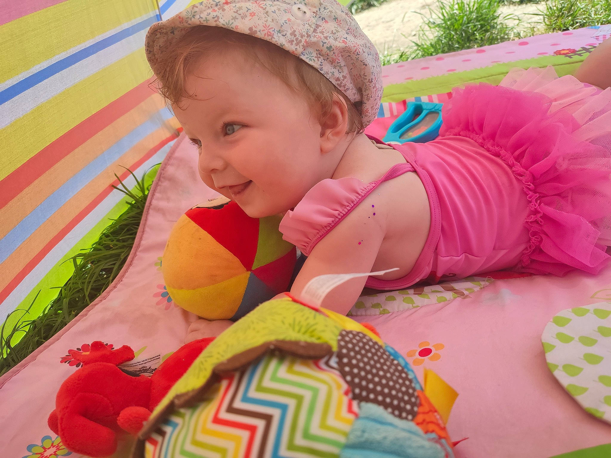 Lanna a rejoint le concours — aidez-le/la à gagner de superbes lots ! baby, baby_products, baby_toddler_clothing, cap, child, comfort, facial_expression, fun, grass, happy, headgear, leisure, pattern, person, pink, recreation, skin, smile, textile, toddler