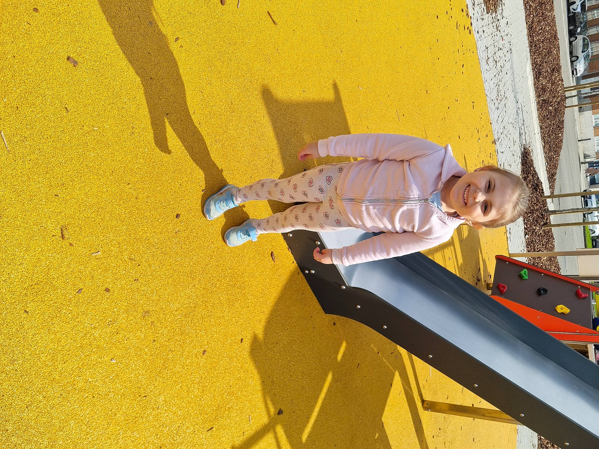 Ylana a rejoint le concours — aidez-le/la à gagner de superbes lots ! adventure, child, city, concrete, elbow, fun, human_leg, joy, landscape, leisure, orange, outdoor_play_equipment, person, play, playground, recreation, shadow, soil, toddler, walking_shoe