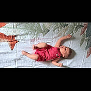 Lucious is registered to the contest to win money with this photo: baby, infant, child, lying_down, striped_clothing, romper, blanket, patterned_blanket, happy, playful, arms_up, legs_up, indoor, cute, smile, head, person, skin, young_child, resting