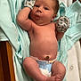 Lucious is registered to the contest to win money with this photo: baby, infant, mittens, diaper, blanket, blue, cute, lying_down, face, expression, newborn, soft, clothing, nursery, child, skin, foot, hand, bed, cute_expression