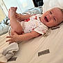 baby, baby_boy, baby_girl, bed, blanket, child, clothing, cute, foot, hand, happy, indoor, infant, joy, lying_down, onesie, person, pillow, skin, smiling
