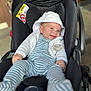 baby, black, car_seat, child, closeup, clothing, comfort, cute, happy, hooded_jacket, indoor, infant, infant_clothing, pacifier, person, safety_warning, seat_belt, smile, striped_onesie, young_child