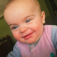 Téora participe au concours pour gagner de l'argent avec cette photo : baby, child, blue_eyes, smile, face, closeup, cute, infant, pink_clothing, gray_clothing, cheeks, happy, portrait, indoors, young_child, expression, person, soft_light, wearing, apparel