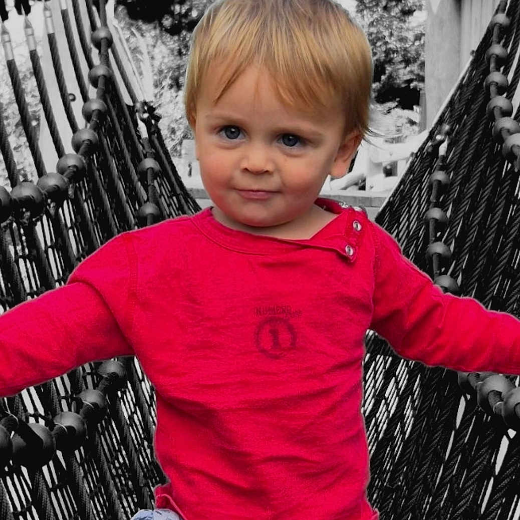 Maoni participe au concours pour gagner de l'argent avec cette photo : black_rope, blonde_hair, blue_eyes, casual_wear, child, confident, daylight, monochrome_background, nature, outdoor, playground, red_shirt, rope_bridge, shorts, smiling, summer_clothing, toddler, walking, wooden_structure, young_child